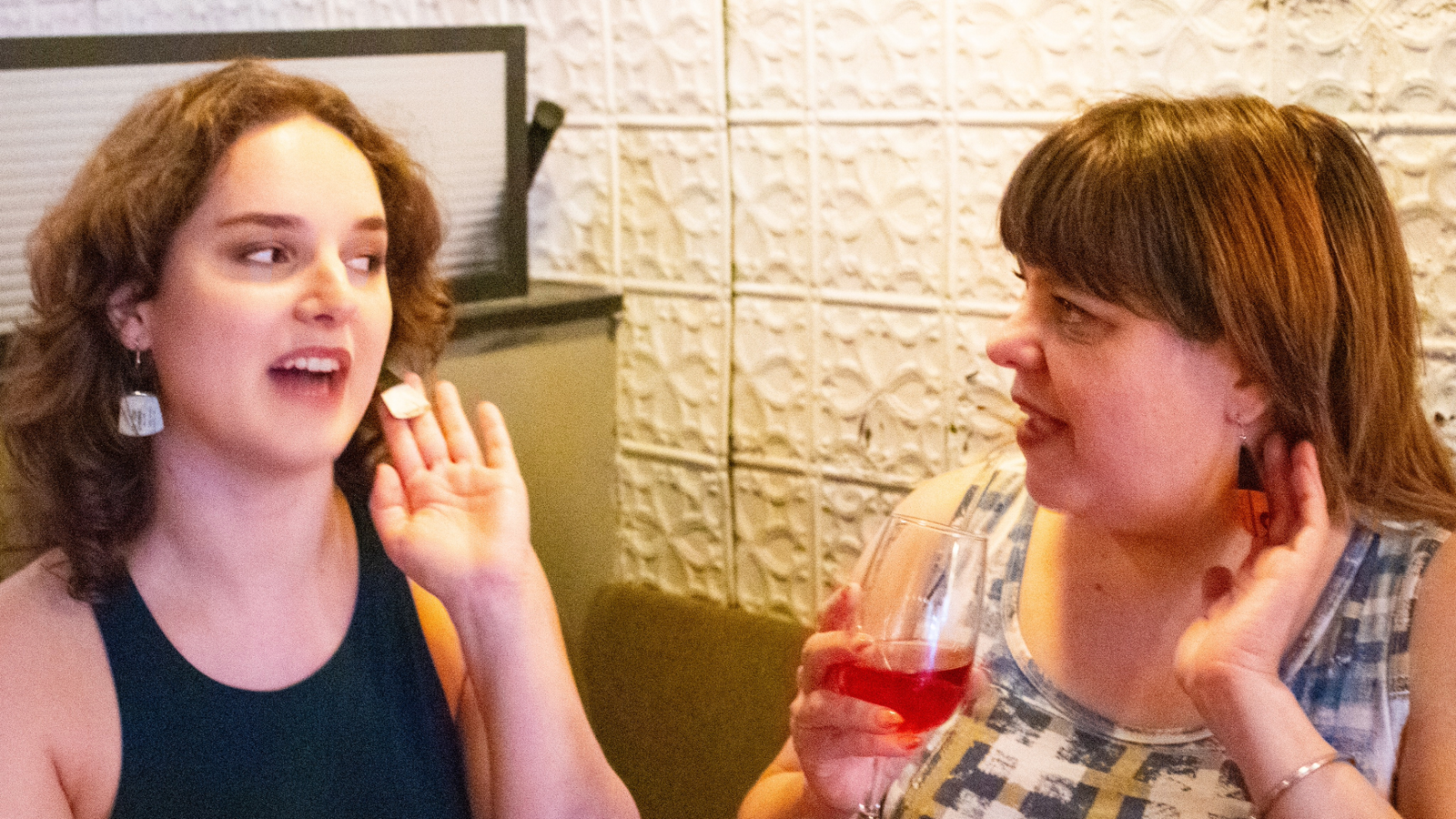 Two women wearing reVinyled earrings